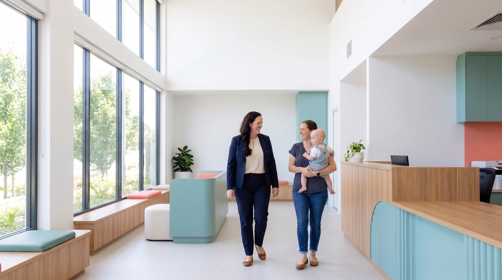 Dr O’Reilly walking through the sunlit clinic with a mother holding her baby